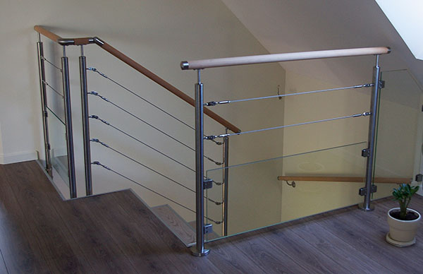 Un garde-corps cable et verre situé en haut d'un escalier